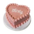 Rose gold heart-shaped cake with a smooth blush finish, shell piping around the edge and base, and personalised white message on top