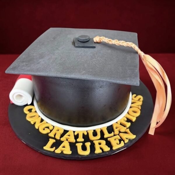 Black 3D Graduation Day Cake shaped like a mortarboard with square cap top, gold tassel, rolled diploma and custom congratulations lettering