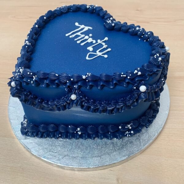 Navy blue vintage Lambeth heart cake with scalloped piped swags, layered shell borders, white pearl accents and custom centre message