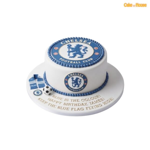 White Chelsea birthday cake with an oversized top badge, matching side crest, blue beaded icing borders, miniature scarf and football