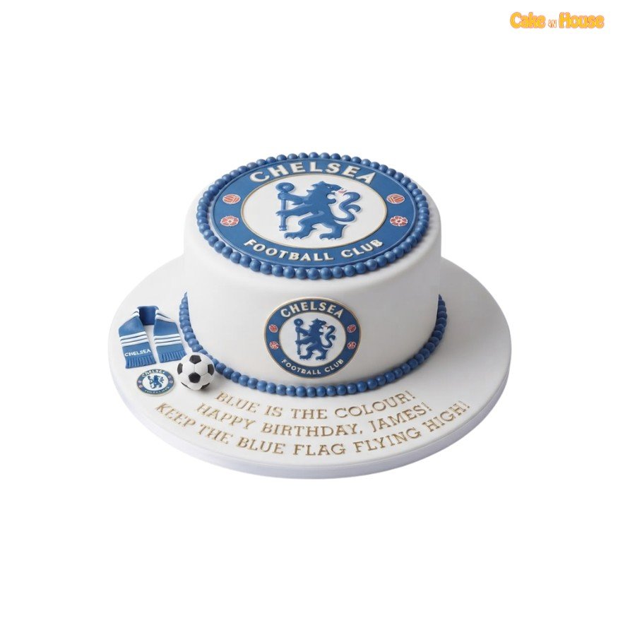 White Chelsea birthday cake with an oversized top badge, matching side crest, blue beaded icing borders, miniature scarf and football