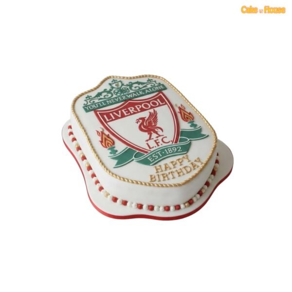 Liverpool FC crest-shaped birthday cake with smooth white fondant, detailed red-and-green club artwork, gold rope edging and pearl trim