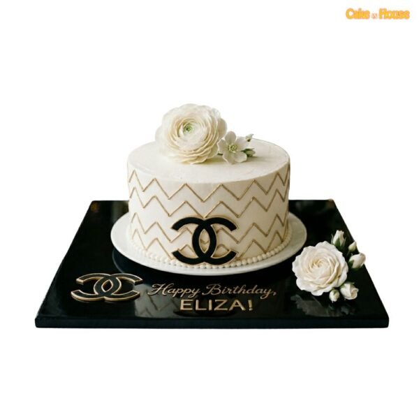 Chanel gold zigzag floral cake with ivory icing, black and gold CC logo, white flower topper, pearl border and black base