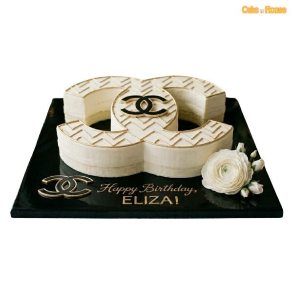 Gold pattern Chanel CC cake with ivory icing, sculpted designer shape, gold geometric detail, logo accent and white flower