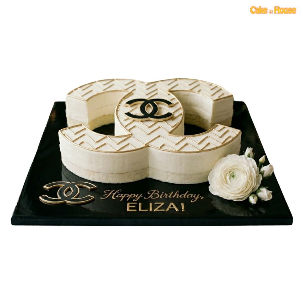 Gold pattern Chanel CC cake with ivory icing, sculpted designer shape, gold geometric detail, logo accent and white flower
