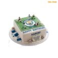 Square Manchester City football pitch cake with green field, central club crest, player figurines, white goals, blue scarf and football decorations