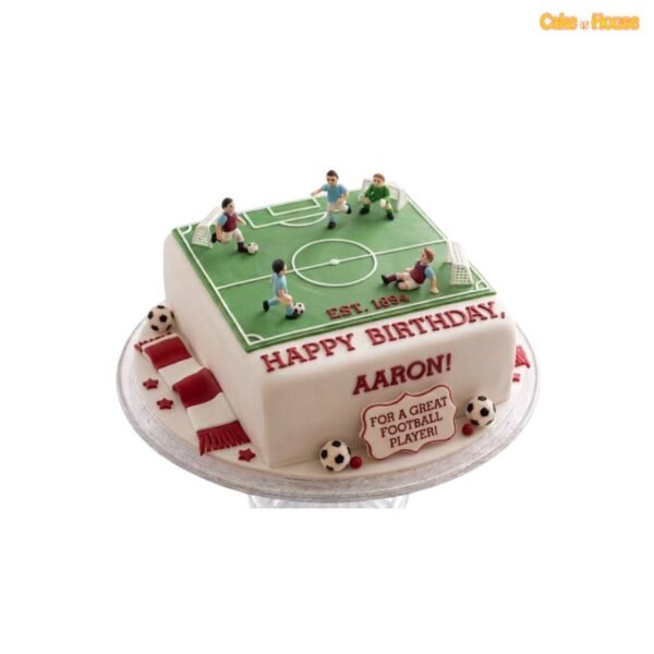 Square football pitch birthday cake with green field, white markings, football player figures, goals, miniature balls and red-and-white scarf